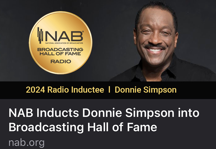 Donnie Simpson smiling wearing black shirt with National Association of Broadcasting Hall of Fame logo